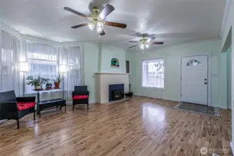 Living room with certified fireplace insert & maple floors.   Large windows keep the interior bright.