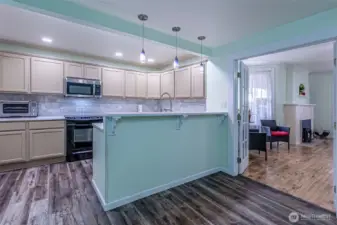 Kitchen view to the living room with French doors open.   Laminate floors in the kitchen, dining, mudroom & utility rooms.
