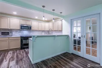 Updated kitchen with serving has quartz counters & coordinating subway tile for interest.