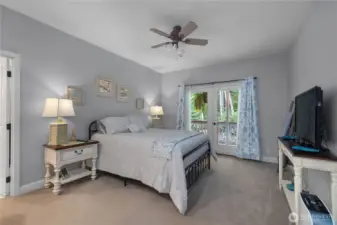 Primary bedroom with ceiling fan and door that takes you to a covered deck.