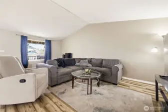 Large open-concept living room, kitchen, and dining area with vaulted ceilings that enhance the spacious feel and natural light.