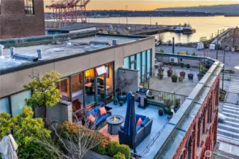 Rooftop context with neighboring warehouse buildings, still carrying the district’s industrial roots