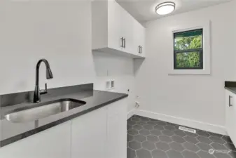 Fantastic laundry room with utility sink, built-ins, & a large countertop for folding