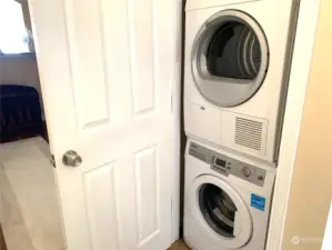 Stack washer and dryer in unit, located in the entry closet outside kitchen.