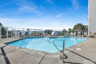 Seasonal heated swimming pool with glass surround and lounging furniture with Bellingham Bay views.