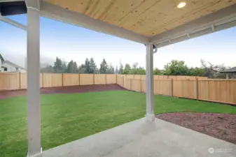 Lit covered patio overlooking a large yard.