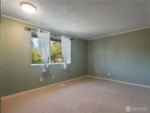 The second spacious bedroom offers full views of the amazing front yard.