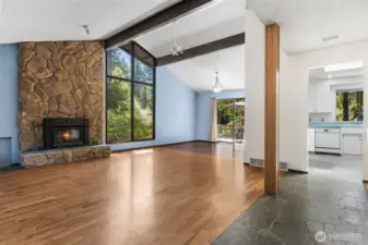 Great room w/ huge picture windows, vaulted ceilings, fireplace insert and hardwood and stone floors
