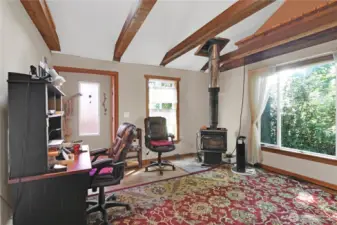 living room off original entrance to home with freestanding wood stove