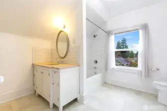 Totally remodeled bathroom with large vanity with stone counter top and a full bath fully tiled.