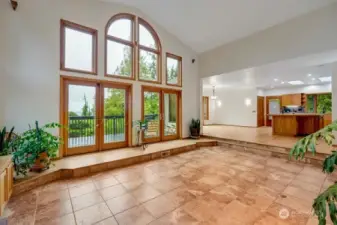 Open concept great room with the kitchen and dining space as well as double doors to access the large deck.