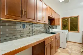 Huge laundry/utility located on the main level with utility sink, tons of storage and counter space.