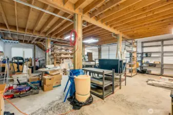 1,200 sqft lower level of the shop with shelving, work benches and three shop bay doors that allow large vehicles to pull all the way in and out the back side of the building.