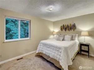 The spacious primary bedroom directly overlooks the tranquility of the private backyard oasis, creating a serene and inviting space.