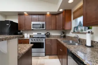 Kitchen with granite countertops. Stainless microwave, stove/range and dishwasher