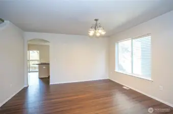 The dining area offers a view into the kitchen and is enhanced by a striking, oversized picture window that floods the space with natural light.