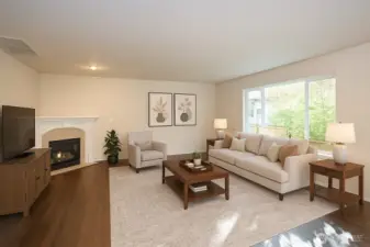 Family room showcasing a cozy gas fireplace and beautiful hardwood floors.