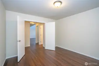 Main-floor den/office with double doors, featuring stunning hardwood floors that extend throughout the entire home.