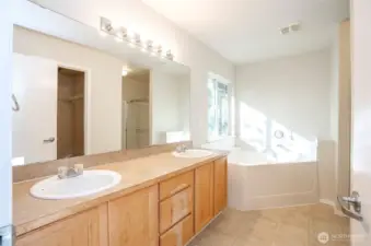 The primary ensuite boasts dual sinks and a relaxing soaking tub, with a walk-in shower and water closet conveniently located just around the corner.