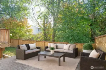 Stamped concrete patio located just below the deck - Virtually staged to inspire your vision of the space.