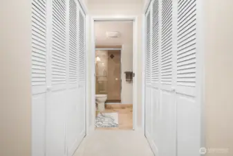 Hallway lined with double louvered closets offers generous storage for the guest suite.