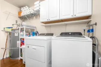 Dedicated laundry room with cabinet storage and utility shelving keeps everything organized. (Note: washer, dryer, and chest freezer do not convey.)
