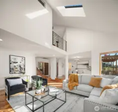 Another angle of the main living area to the vaulted ceilings and a view of the second floor. To the left of the stairs is an extra room which could be a 4th bedroom, home office, gym, or studio.