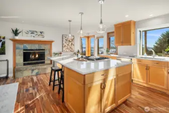 The kitchen enjoys a spectacular view to the SW. Center island, quartz countertops, high end appliances, stylish lighting, and newer acacia wood flooring add extra warmth and pizzaz to this perfect space for cooking, and entertaining. Ample seating at the island to converse wiht your guests.