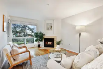 Spacious living room with oversized picture window overlooking condo grounds.