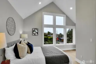 Primary bedroom with vaulted ceilings, large view windows and a private view deck!