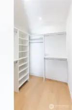 Primary bedroom walk in closet with closet system installed