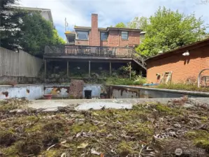View of old swimming pool from alley.