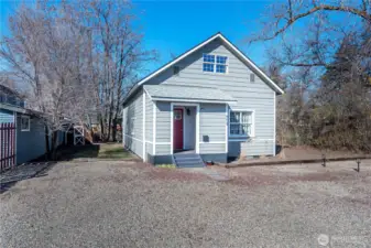 The south side of the home has a grassy area leading to the fenced back yard and little garden shed.