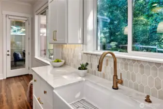 Large window overlooks yard and green belt.