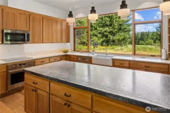 Quartz counters surround the kitchen with hickory custom cabinets. The microwave also is a double oven.