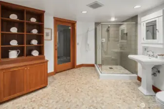 Glass-walled walk-in shower, built-in shelving, accessible to pool deck and fitness studio