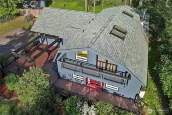 Aerial view of front of house. New Skylights 2020. One Primary bedroom has French doors to upper deck. Lower deck wraps front of house with large entertainment area.  House painted in Fall of 2024.