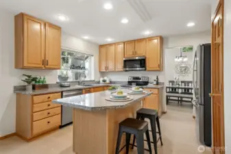 More good lighting and garden window lets  in the daylight! Lots of granite counters,  cabinets + pantry and center island together  make for a very friendly kitchen!