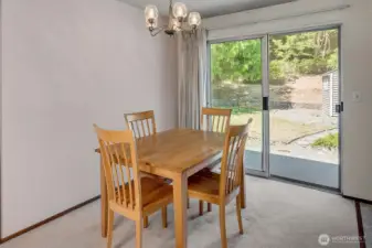 Large dining room with sliders to fully fenced backyard.