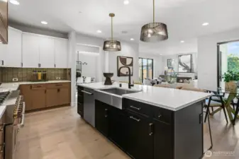 Gorgeous mixed canvas on cabinets. Island painted in classic black anchors the kitchen, rift sawn oak cabinets on the base and perimeter refrigerator/freezer wall, and painted white uppers. Matte black and brushed gold hardware. Large single-basin stainless steel sink.