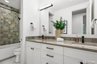 Upper level hall bath with double sink vanity, and a pocket door that provides privacy for the tub/shower room.