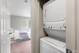 Hallway to Primary Suite – The hallway leads into the spacious primary suite and includes the first set of laundry machines for convenient main-level living.