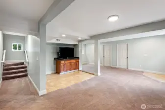 Basement Living Room Facing Stairs – The finished basement living area connects to the main level via the staircase and offers access to two additional bedrooms or bonus rooms.