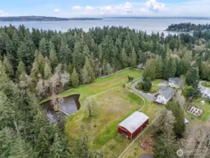 Aerial View of Property – Aerial perspective showing the expansive acreage, home, barn, and surrounding landscape of this fully fenced 4.6 acres.