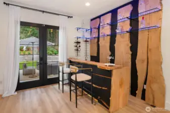 Custom bar crafted from wood slabs salvaged from the property