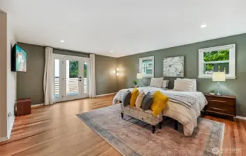 Large and expansive primary suite opens to deck and fully fenced backyard.