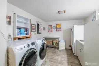 This large laundry room with sink has plenty of room, with a wine/pantry room in the back.
