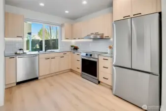 Bright, modern kitchen with soft-close cabinets, Stainless Steel appliances, finish a minimalist design.