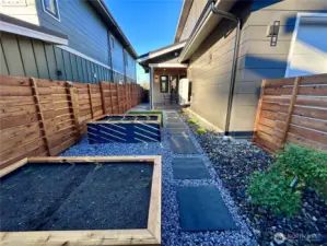 Fenced backyard with large planter boxes and easy landscape