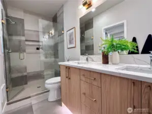 Primary en suite with motion activated under cab lighting, full tile and glass enclosure shower.